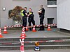 Polizisten stehen hinter Absperrband und Verkehrskegeln vor einem Wohnhaus.
