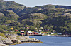 Buntes Dorf an der Küste von Tröndelag in Norwegen vor steilen Bergen.