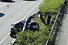 Verunglücktes Auto unter der Mittelleitplanke an der A27 bei Achim, daneben ein Polizist.
