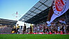 Spieler laufen im Millerntor-Stadion auf, Heimfans feiern vor der Tribüne.