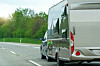 Pkw zieht Wohnwagen auf der Autobahn, unterwegs in den Urlaub.