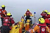 Seenotretter in Rettungsbooten bereiten vor Miedzyzdroje die Befreiung eines Wals aus Fischernetzen vor.