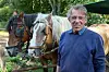 Jürgen Hillmer steht in der Lüneburger Heide neben zwei deutschen Kaltblütern.