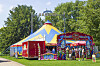 Buntes Zirkuszelt des Zirkus Quaiser im Hamburger Park Große Wallanlagen, davor stehen Besucher.