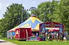 Buntes Zirkuszelt des Zirkus Quaiser im Hamburger Park Große Wallanlagen, davor stehen Besucher.