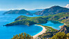 Türkisfarbene Bucht mit Sandstrand und bewaldeten Bergen bei Dalaman an der türkischen Küste