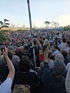Dicht gedrängte Menschenmenge verfolgt eine Open-Air-Veranstaltung, viele halten Smartphones hoch.