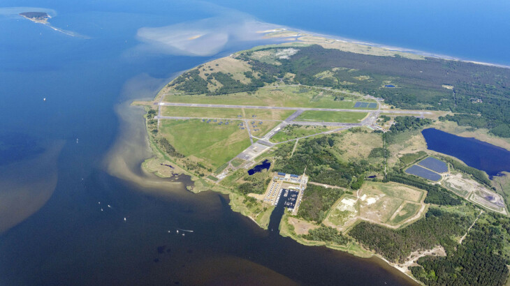 Luftbild des Flugplatzes Peenemünde mit Startbahnen, Hafen und Küste an der Ostsee