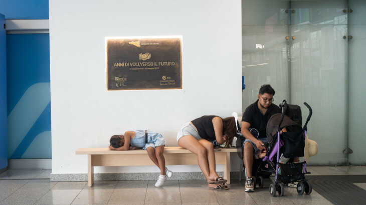 Reisende mit Kinderwagen warten am Flughafen Catania nach neuen Ausbrüchen des Ätna.