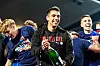 Marcel Rapp feiert mit Holstein-Kiel-Fans den Bundesliga-Aufstieg und hält eine Champagnerflasche.