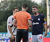 Jonas Meffert und ein Mitspieler sprechen im Holstein-Stadion mit Schiedsrichter Max Burda.