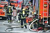 Feuerwehrleute löschen einen Dachstuhlbrand am Eppendorfer Baum; Schläuche und Einsatzfahrzeuge stehen auf der Straße.