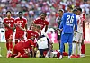 Teamarzt Jochen Hahne versorgt einen liegenden Bayern-Spieler; Jamal Musiala und weitere Profis stehen daneben.