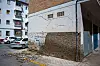 Rissiges Gebäude mit abgeplatztem Putz und Trümmern auf einer Straße in Granada