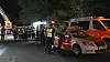 Feuerwehrkräfte stehen nachts neben Einsatzfahrzeugen am ehemaligen Berghotel Hamburg Blick am Wulmsberg.