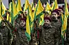 Hisbollah-Kämpfer in Tarnuniformen und mit gelb-grünen Fahnen bei einer Beerdigung im Südlibanon