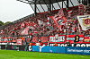Dicht gefüllte Westkurve von Rot-Weiss Essen mit roten Fahnen und Bannern im Stadion an der Hafenstraße in Essen.
