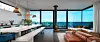 Modernes Loft mit Küche, Ledersofa und Panoramafenstern mit Blick auf das Meer