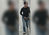 Unkenntlich gemachte Person in schwarzem Oberteil und Jeans auf einem schmalen Gehweg