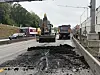 Bagger und Lastwagen bei Straßenarbeiten auf einer innerstädtischen Fahrbahn