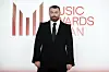 Sam Smith posiert im schwarzen Anzug vor dem Logo der Music Awards Japan in Tokio.