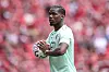 Paul Pogba von AS Monaco hält vor dem Spiel gegen Liverpool einen Fußball vor roter Fankulisse.