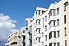 Moderne Mehrfamilienhäuser unter blauem Himmel; bei Immobilienerbe kann die Eigennutzung steuerlich entscheidend sein.