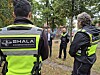Sicherheitskräfte von SHALA stehen auf einem bewaldeten Gelände mit weiteren Personen im Hintergrund.