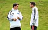 Merlin Polzin und Claus Costa sprechen im HSV-Trainingslager in Längenfeld auf einer Wiese.