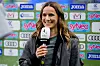 Christina Rann lächelt mit SPORT1-Mikrofon vor einer Sponsorenwand in Sinsheim.