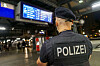 Polizeibeamter überwacht den Hamburger Hauptbahnhof unter einer Anzeigetafel während der Waffenverbotszone.