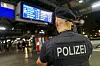 Polizeibeamter überwacht den Hamburger Hauptbahnhof unter einer Anzeigetafel während der Waffenverbotszone.