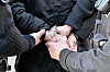 Polizisten legen einer festgehaltenen Person in Kiel Handschellen an.