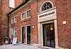Eingang des Meeresmuseums in Stralsund mit roter Backsteinfassade, Portal, Fahrrad und Hinweistafel.