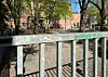 Tor zum Schulhof einer Grundschule in Bremen vor dem Hauptgebäude, umgeben von Bäumen.