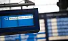 Digitale Bahnhofstafel mit Hinweis auf einen Zugausfall, im Hintergrund weitere unscharfe Anzeigetafeln