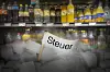 Zuckerhaltige Softdrinks im Supermarktregal, darüber ein Schriftzug mit dem Wort „Steuer“.