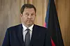 Lars Klingbeil im Anzug vor einer Deutschlandflagge beim Finanzministertreffen in Schaan