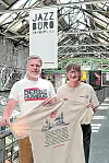 Zwei Menschen präsentieren ein Jazz-T-Shirt in einer historischen Hamburger Industriehalle.