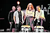 Fünf Musikerinnen und Musiker stehen auf einer dunklen Bühne hinter zwei Schlagzeugen.