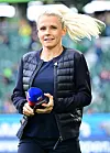 Julia Simic steht mit Mikrofon am Spielfeldrand des Bundesliga-Spiels Wolfsburg gegen Bayern München.