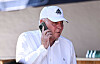 Uli Hoeneß telefoniert in weißem Hemd und Adidas-Kappe vor dem Testspiel des FC Bayern München.