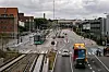 Stadtbahn, Busse und Autos auf einer mehrspurigen Verkehrsachse in Kopenhagen bei bewölktem Himmel