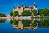 Schweriner Schloss am Burgsee mit Türmen, Uferbäumen und klarer Spiegelung im Wasser