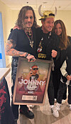 Johnny Depp, Lorenz Büffel und Emily posieren in Köln mit einer gerahmten Platin-Schallplatte zu „Johnny Däpp“.