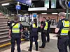 Mehrere Einsatzkräfte in Warnwesten stehen im Bahnhof Harburg an einer Treppe.