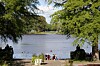 Zwei Frauen genießen auf der Liebesinsel im Stadtpark die Sonne am See.