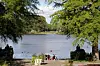 Zwei Frauen genießen auf der Liebesinsel im Stadtpark die Sonne am See.