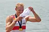 Oliver Zeidler feiert im Wasser seinen Sieg im Einer mit Medaille und weißem Tuch.