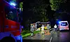Feuerwehr, Rettungswagen und Einsatzkräfte sichern nachts eine Straße unter blauem Blaulicht.